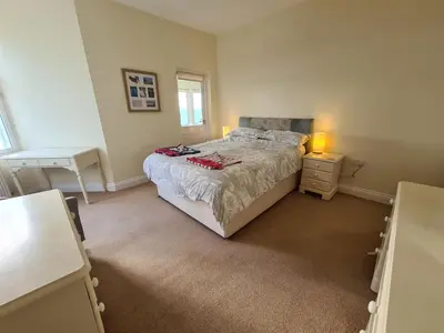 a bedroom with a bed and a desk and two lamps at Upper Tresulian in Saint Mawes