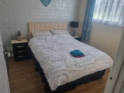 a bedroom with a bed with a white comforter at Villa Sleeps 4 with Free Parking in Camelford
