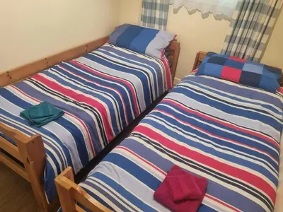 two beds sitting next to each other in a room at Villa Sleeps 4 with Free Parking in Camelford
