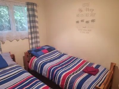 two beds sitting next to each other in a bedroom at Villa Sleeps 4 with Free Parking in Camelford