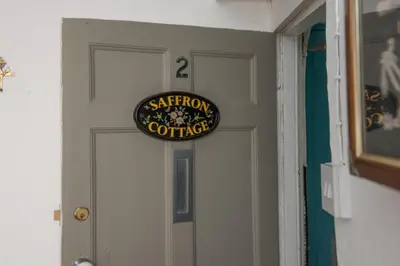a door with a sign for a bathroom coordinator at Saffron Cottage, St Ives in St Ives