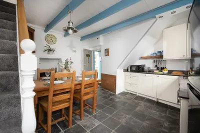 a kitchen with a table and chairs in a room at Saffron Cottage, St Ives in St Ives