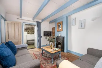 a living room with a couch and a table at Saffron Cottage, St Ives in St Ives