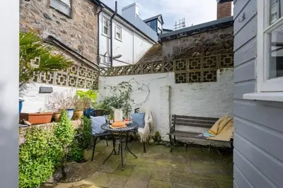 a small patio with a table and a bench at Saffron Cottage, St Ives in St Ives