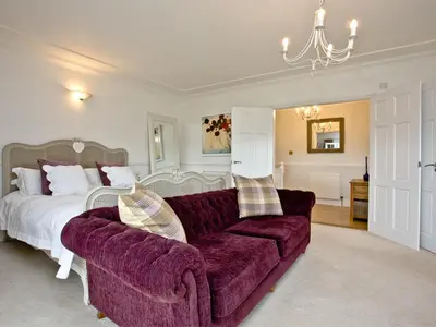 a bedroom with a purple couch and a bed at Hewas Water House in Grampound