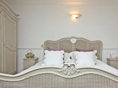a bedroom with a white bed with purple pillows at Hewas Water House in Grampound