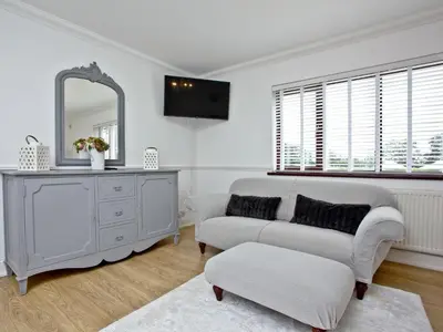 a living room with a couch and a mirror at Hewas Water House in Grampound