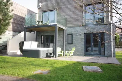 a glass house with a table and chairs in a yard at House 10 in Looe