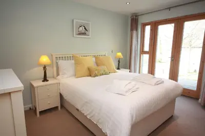 a bedroom with a white bed with two towels on it at House 10 in Looe