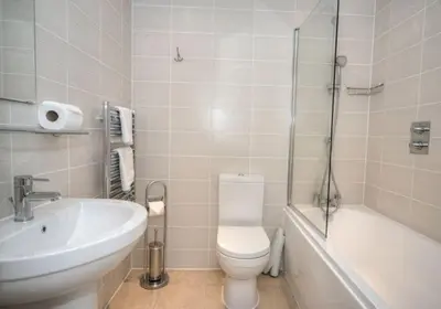 a bathroom with a toilet and a sink and a bath tub at House 10 in Looe