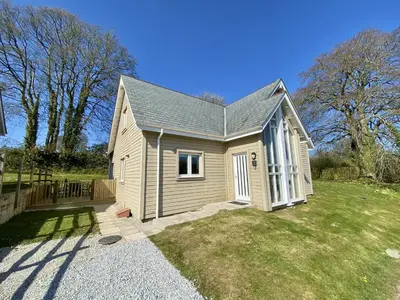 a small house in a yard next to a field at Trewhiddle Retreat V1 by Together Travel - Luxury 4-Bedroom Villa in St Austell