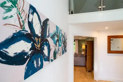 a room with a painting on the wall at Trewhiddle Retreat V1 by Together Travel - Luxury 4-Bedroom Villa in St Austell