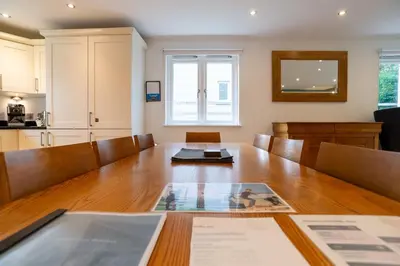 a dining room with a table and a kitchen at Trewhiddle Retreat V1 by Together Travel - Luxury 4-Bedroom Villa in St Austell