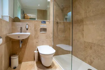 a bathroom with a toilet and a sink and a shower at Trewhiddle Retreat V1 by Together Travel - Luxury 4-Bedroom Villa in St Austell