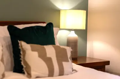a bedroom with a bed with a lamp on a table at Trewhiddle Retreat V1 by Together Travel - Luxury 4-Bedroom Villa in St Austell