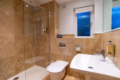 a bathroom with a shower and a toilet and a sink at Trewhiddle Retreat V1 by Together Travel - Luxury 4-Bedroom Villa in St Austell