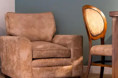 an old chair sitting next to a wooden chair at Trewhiddle Retreat V1 by Together Travel - Luxury 4-Bedroom Villa in St Austell