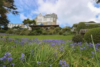 a house with a garden with purple flowers at The Tower, 5 Corisande Manor in Newquay