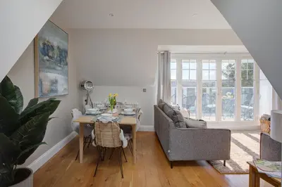a living room with a table and a couch at The Tower, 5 Corisande Manor in Newquay