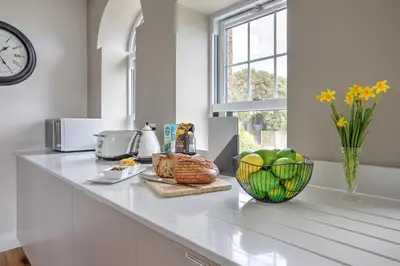 a kitchen counter with a bowl of apples and a window at The Tower, 5 Corisande Manor in Newquay
