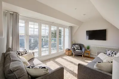 a living room with two couches and a large window at The Tower, 5 Corisande Manor in Newquay