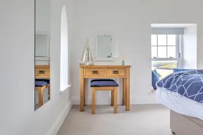 a bedroom with a desk with a bed and a mirror at The Tower, 5 Corisande Manor in Newquay
