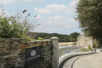 a sign on a wall next to a walkway at The Tower, 5 Corisande Manor in Newquay