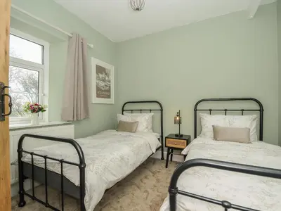 a bedroom with two beds and a window at Skylarks in Looe