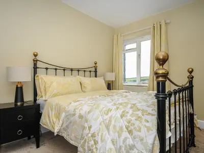 a bedroom with a bed and a window at Skylarks in Looe