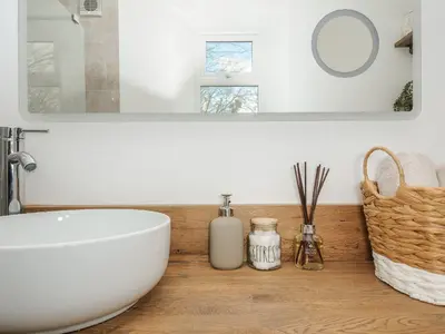 a bathroom with a white bowl sink and a mirror at Skylarks in Looe