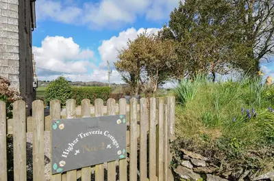 a sign on a wooden fence in front of a house at Skylarks in Looe