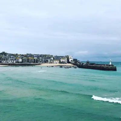 a view of the ocean with a beach and a lighthouse at Little Haven St Ives - with parking in St Ives