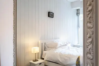 a bedroom with a white bed and a mirror at Seapinks in Port Isaac
