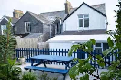 a blue picnic table in front of a white house at Seapinks in Port Isaac