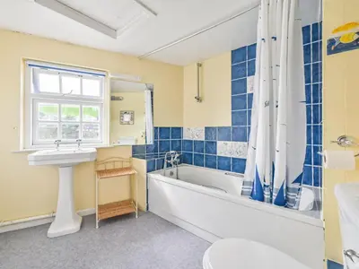 a bathroom with a bath tub and a sink and a bath tub at Holiday Home Dolphin Cottage by Interhome in Mevagissey