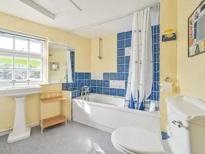 a bathroom with a tub and a toilet and a sink at Holiday Home Dolphin Cottage by Interhome in Mevagissey