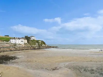 a beach with houses on a hill next to the ocean at Holiday Home Dolphin Cottage by Interhome in Mevagissey