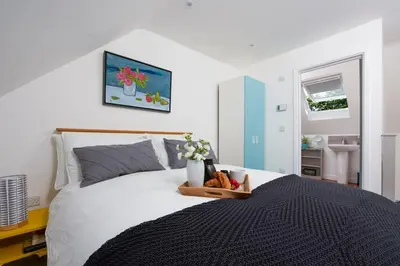 a bedroom with a bed with a tray of flowers on it at The Studio, Rosebud. 5 minutes walk to beach. in Uny Lelant