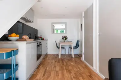 a kitchen with a counter and a table with chairs at The Studio, Rosebud. 5 minutes walk to beach. in Uny Lelant