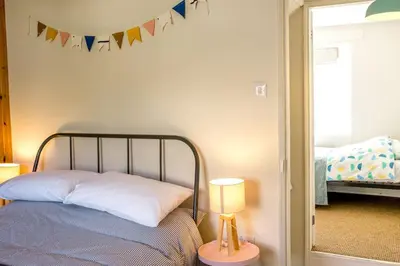 a bedroom with a bed and a lamp and flags at Stylish cottage in the heart of town in Lostwithiel