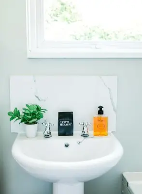 a white sink in a bathroom with a window at Stylish cottage in the heart of town in Lostwithiel