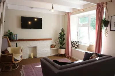 a living room with a couch and a fireplace at Stylish cottage in the heart of town in Lostwithiel