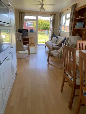 a living room with a couch and a table at Chalet 86, Atlantic Bays Holiday Park in St Merryn