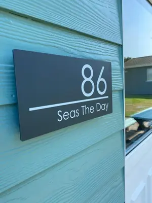 a sign on a building that says sees the day at Chalet 86, Atlantic Bays Holiday Park in St Merryn