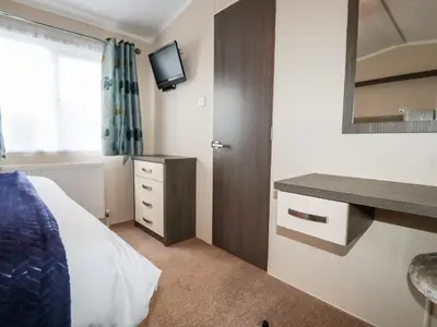 a bedroom with a bed and a desk and a television at Lake View 10 in Par