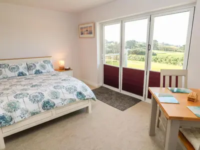 a bedroom with a bed and a table and a window at Greenside Studio in Penzance