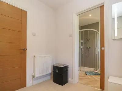 a bathroom with a walk in shower and a black trash can at Greenside Studio in Penzance