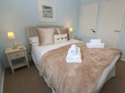 a bedroom with a bed with towels on it at Bumbles in Padstow
