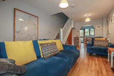 a blue couch with yellow pillows in a living room at Bumbles in Padstow
