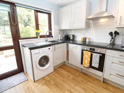 a kitchen with a washing machine and a sink at Bumbles in Padstow